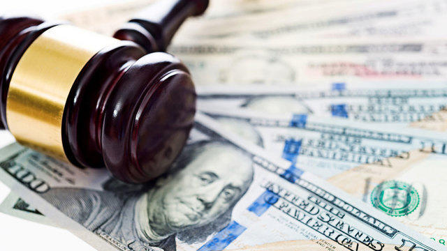 Gavel on top of one hundred dollar bills