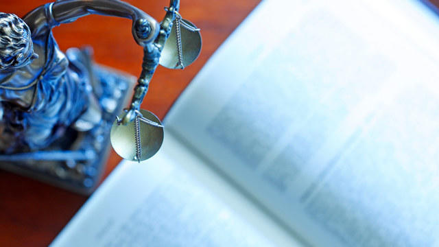 Justice scales and law book on table