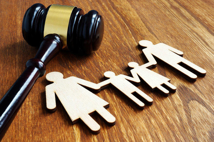 Gavel next to cut out of family holding hands